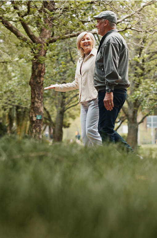 An older couple walking together in the woods