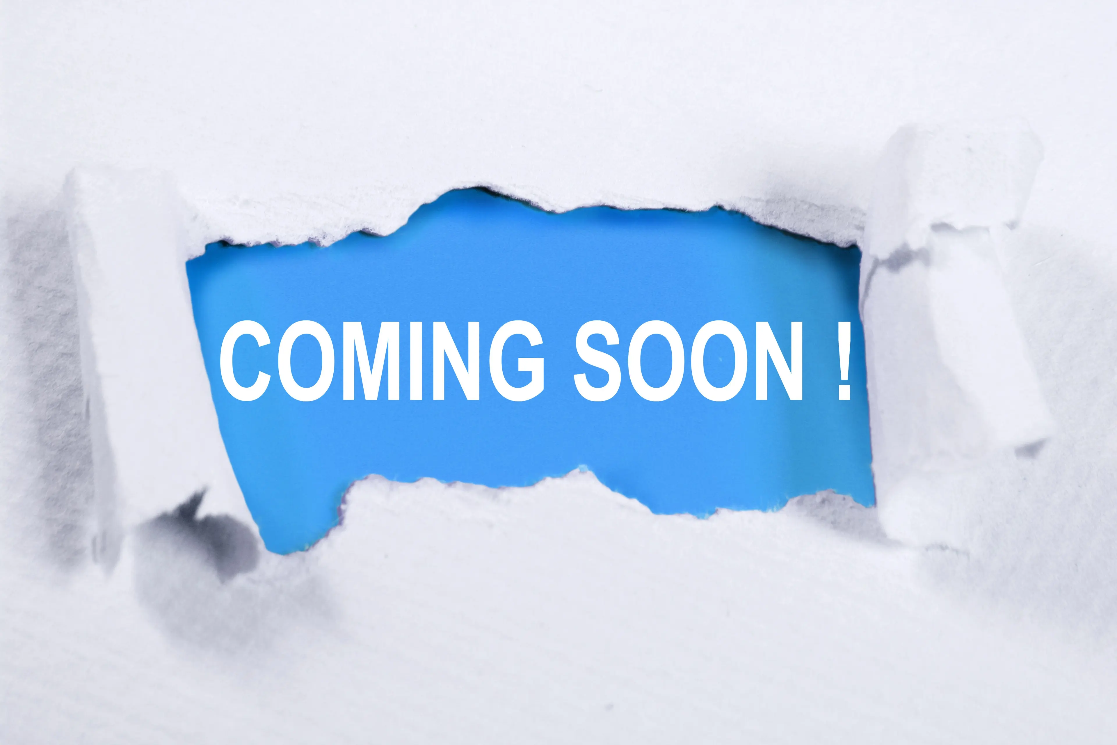 Torn paper revealing the words "Coming Soon" underneath