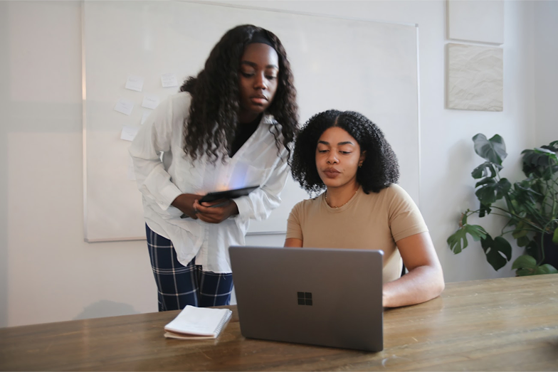 Two women looking at a laptop together.
